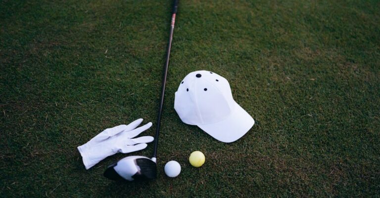 Close-up of golf club, balls, glove, and cap placed on green grass, perfect for a golf day.